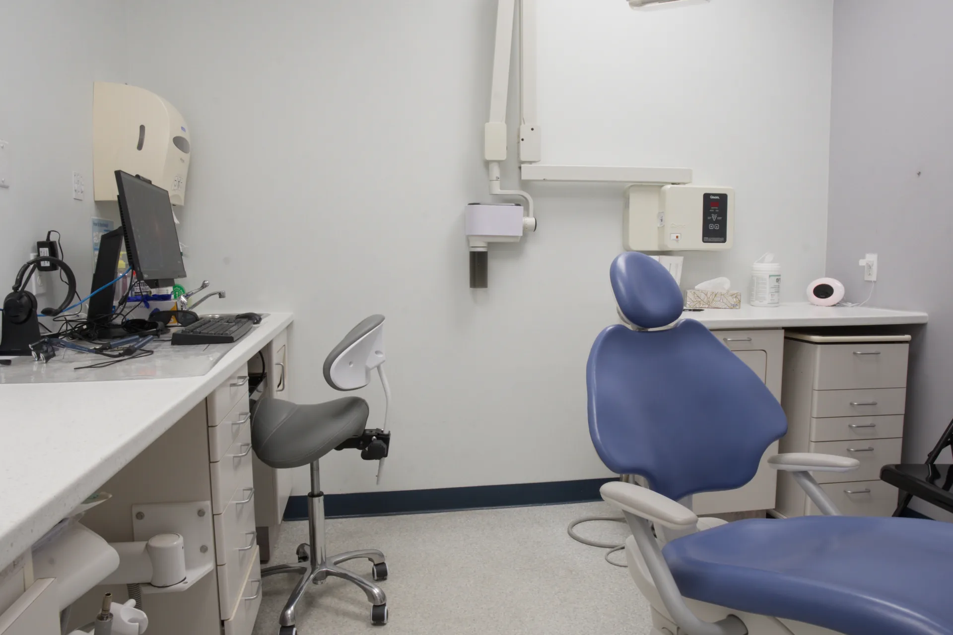 New blue dental chair beside the workstation in the third treatment room